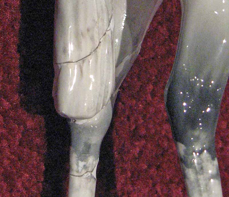 Badly glued tail and leg with visible crack.